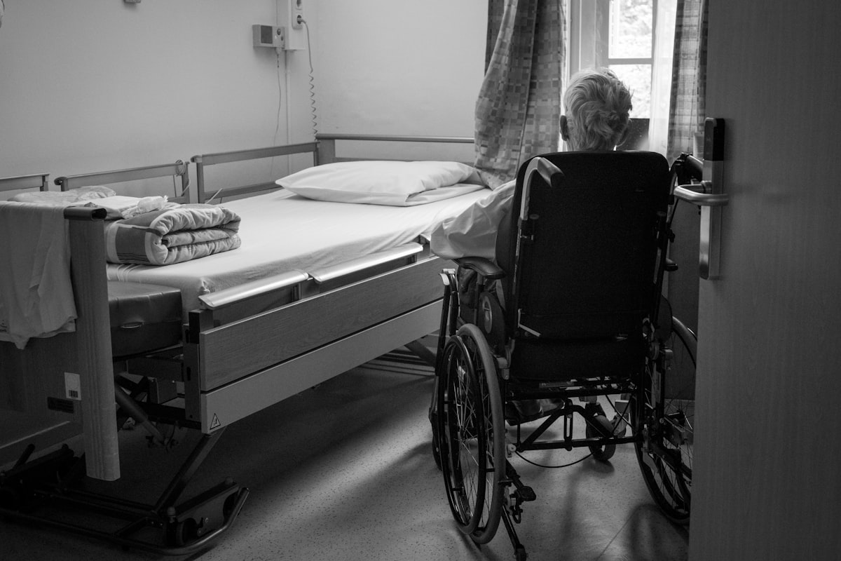WZC-kamer met medisch bed en een bewoner in een rolstoel